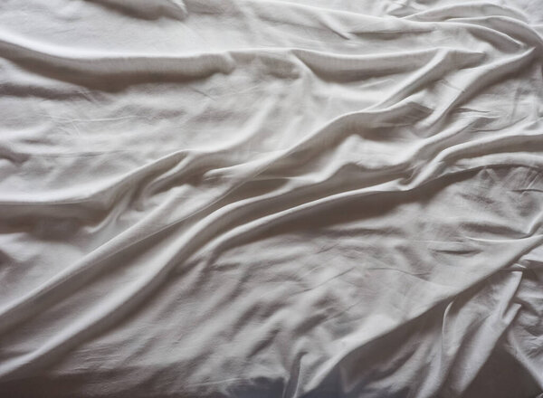 white cotton sheets on an unmade bed