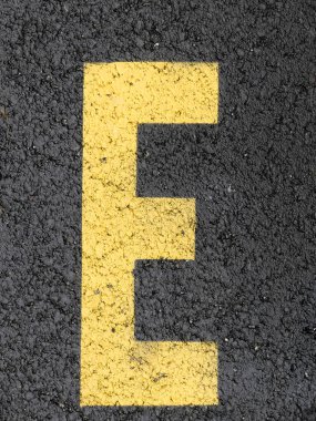 E harfi şablon işareti asfalt üzerindeki sarı boya.