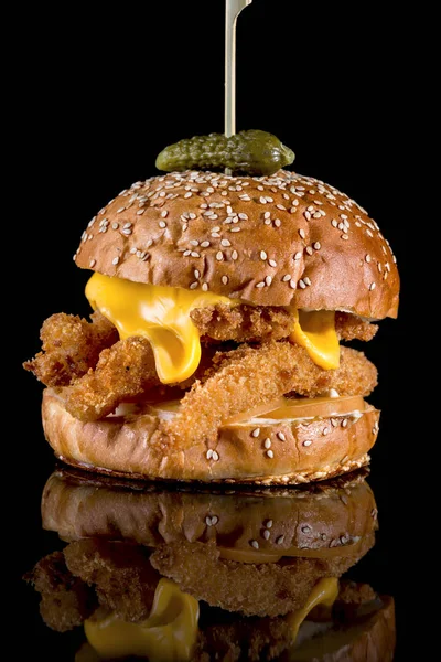 King Fisher Burger - Breaded fish filets, American cheese slice and tartar sauce with reflection isolated on black background