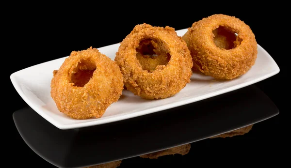 Onion rings isolated on black background with reflection.