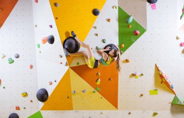 Genç kadın bouldering rota tırmanma kapalı spor salonunda zorlu