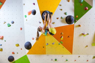 Genç kadın tırmanma bouldering rota. Tırmanma kapalı spor salonunda.