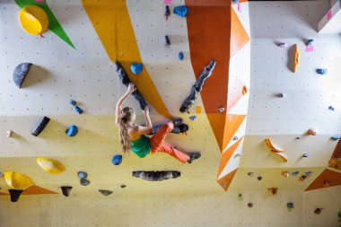 Genç kadın bouldering tırmanma kapalı spor salonunda