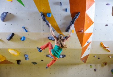 Kayma handholds eller genç kadın spor salonu, tırmanma içinde bouldering iken düşme