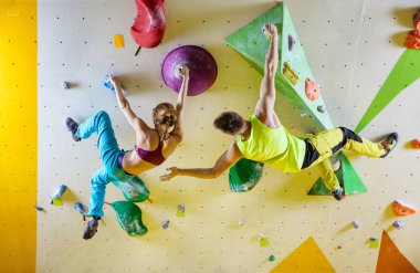 Spor tırmanış içinde kaya dağcılar. Genç çift Bouldering sorunları (yollar), adam kız dağcı teşvik tırmanma.