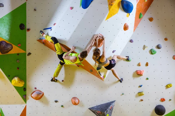 クライミングジムで岩の登山 若いカップル クライミング ボルダリング問題 ルート 同じ握りのグリップ — ストック写真