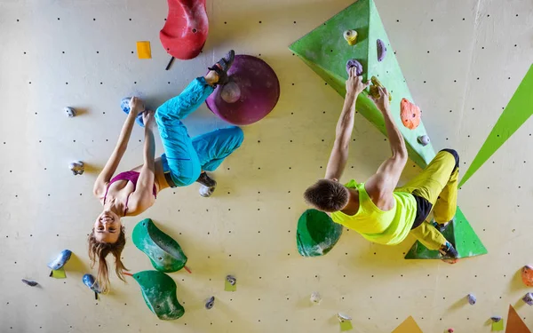 Ροκ Ορειβάτες Στο Γυμναστήριο Bouldering Ανεβαίνοντας Κρεμαστές Τοίχου Νεαρή Γυναίκα — Φωτογραφία Αρχείου