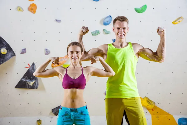 Młody Wesoły Kobieta Mężczyzna Wspinaczy Wyginanie Biceps Przeciwko Bouldering Ściany — Zdjęcie stockowe