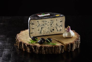 Kalıp peynir, siyah zeytin ve sarımsak siyah arka plan üzerinde parça