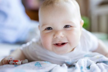 Oyuncakla oynamak, kameraya bakıyor ve gülümseyen şirin bebek kız 