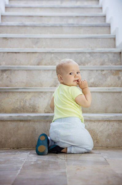 Baby girl at bottom of stairs outdoors