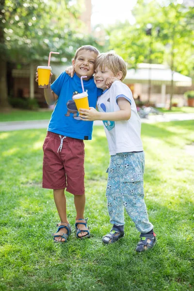 Dois meninos abraçando um ao outro ou lutando brincando enquanto bebem — Fotografia de Stock