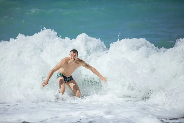 Junger Mann genießt hohe Wellen in rauer See — Stockfoto