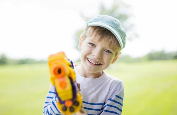 Glad ung pojke med leksak vapen — Stockfoto