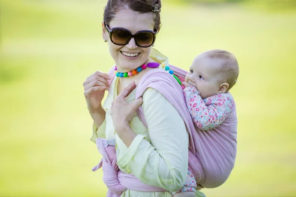 Vidám kaukázusi nő kezében baby lánya vissza — Stock Fotó