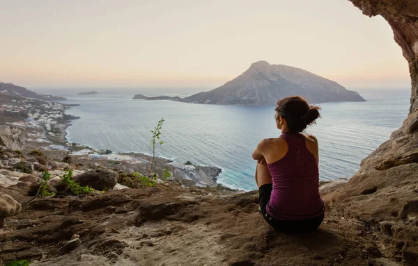 Escaladora sentada en la cueva y observando la puesta de sol — Foto de Stock