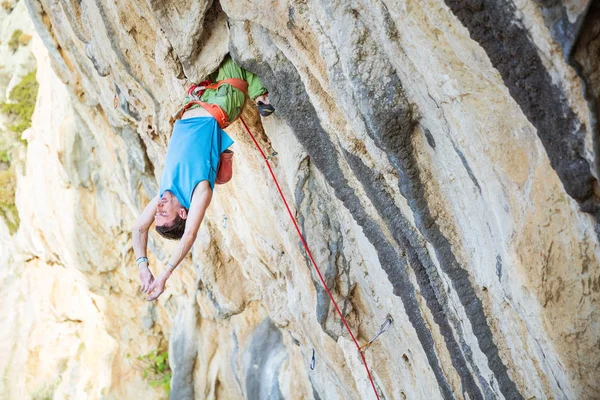 Jonge man rusten tijdens het klimmen uitdagende route — Stockfoto