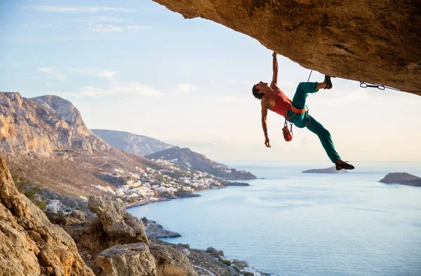 Homme caucasien escalade route difficile dans la grotte au coucher du soleil — Photo