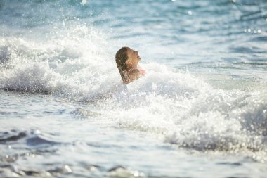 Sahilde dalgalar kırma oynayan genç kız