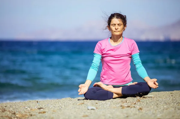 Kaukaski młoda kobieta uprawia jogę na plaży — Zdjęcie stockowe
