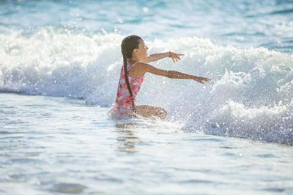 Happy girl playing in breaking waves on beach — Stock Photo, Image