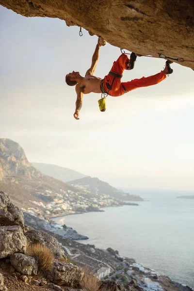 Young man climbing challenging route in cave against beautiful v — Stock Photo, Image
