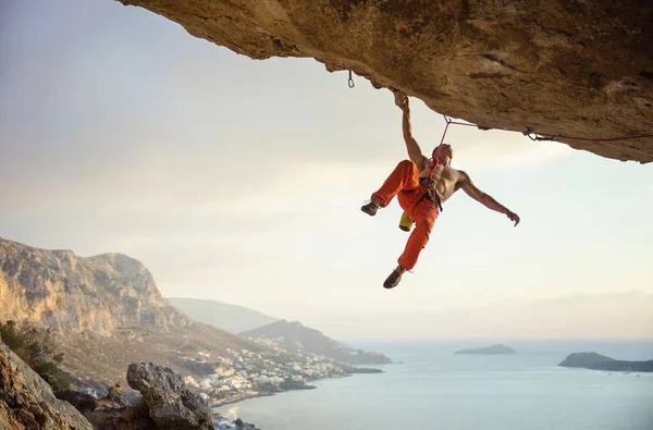 Junger Mann klettert anspruchsvolle Route in Höhle — Stockfoto