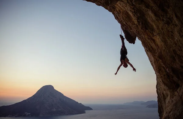 Mladý ženský skalní horolezec visící na laně vzhůru, když se — Stock fotografie