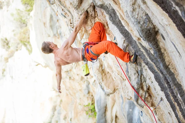 Молодий чоловік піднімається складним маршрутом на висячій скелі — стокове фото