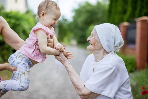 Happy toddler girl and her great grandmother looking at one anot — Stock Photo, Image