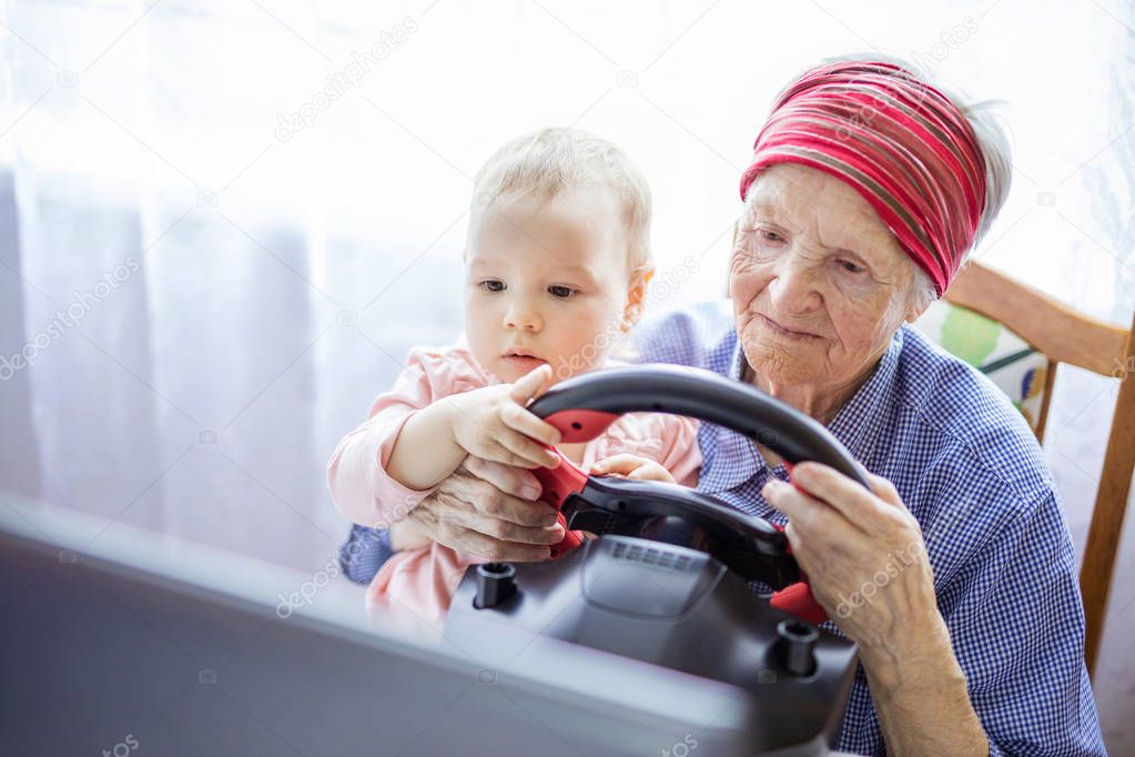 Senior woman and her great granddaughter enjoying car racing vid