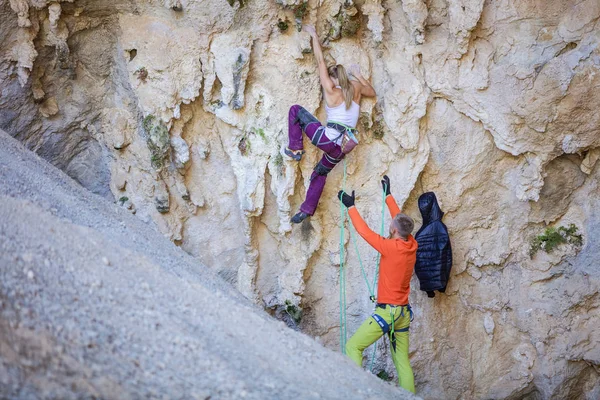 Young Female Climber Starting Challenging Route Cliff Her Partner Belaying — Stockfoto