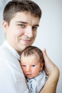 Yeni doğmuş erkek bebek ve onun mutlu babası. Odaklanan bebek.