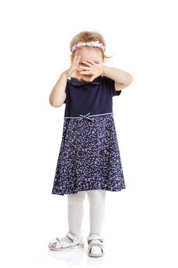Mutlu küçük kız beyaz arka planda peekaboo oynuyor.