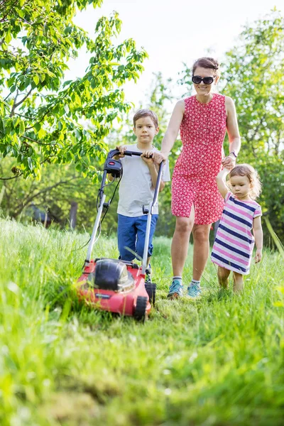 Young Boy Mowing Grass Lawn Mower His Mother Little Sister — Stock Photo, Image