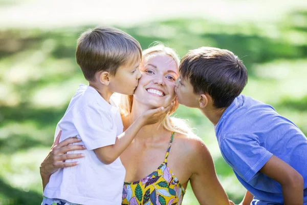 Two Young Boys Kissing Mother Outdoors Park — Stock Photo, Image