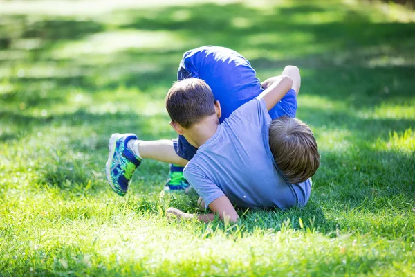 两个男孩在外面打架 在夏季公园的草地上摔跤的兄弟姐妹或朋友 兄弟间的竞争 — 图库照片