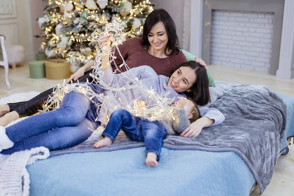 若いです女性 彼女の母親と赤ちゃん息子楽しみます静かな時間近くクリスマスツリーで自宅 — ストック写真