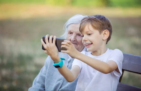 Ung Pojke Och Hans Farmor Använder Smartphone För Att Selfie — Stockfoto