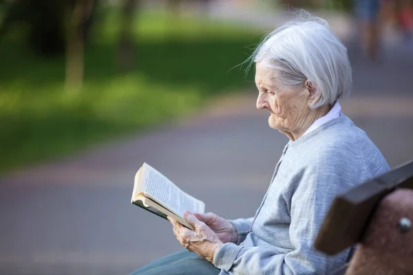 Porträtt Äldre Kvinna Som Läser Skönlitteratur Parken — Stockfoto