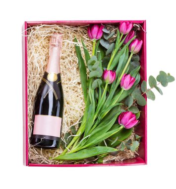 İçinde bir şişe şampanya ve bir buket lale olan bir hediye kutusu.