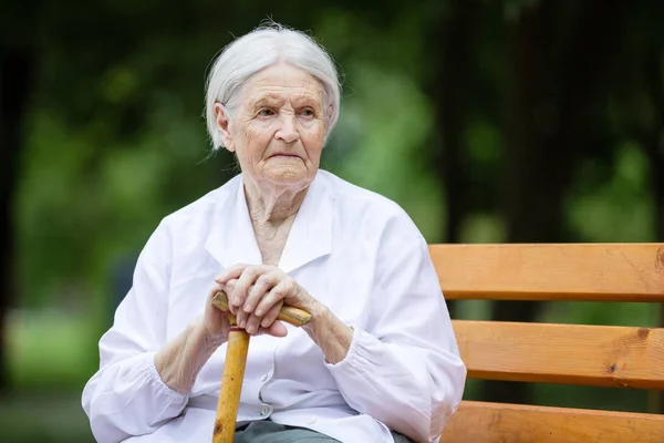 公園のベンチに座っている年配の女性は — ストック写真