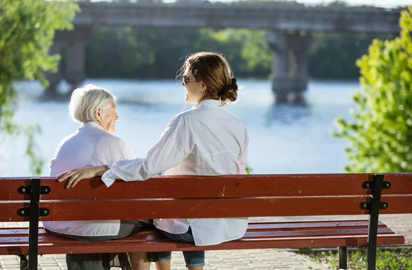 Oudere Vrouw Haar Volwassen Kleindochter Zitten Bank Het Zomerpark Praten — Stockfoto