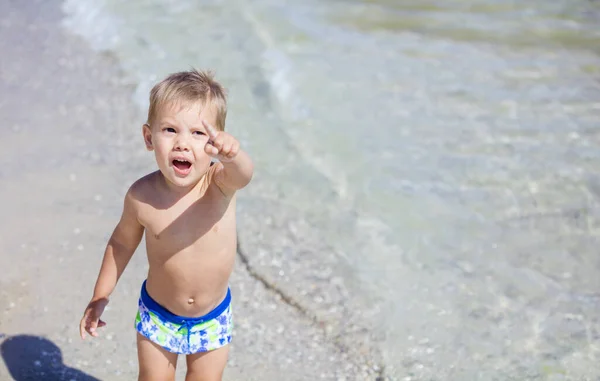 Mały Chłopiec Wskazujący Coś Powyżej Podczas Zabawy Plaży Przestrzenią Kopiowania — Zdjęcie stockowe