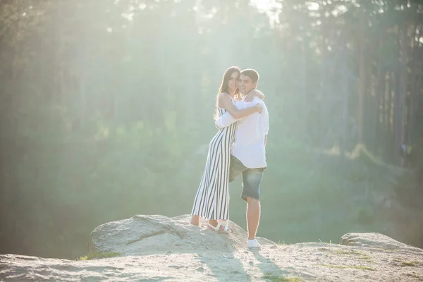 一对浪漫的年轻夫妇站在河的悬崖上 — 图库照片