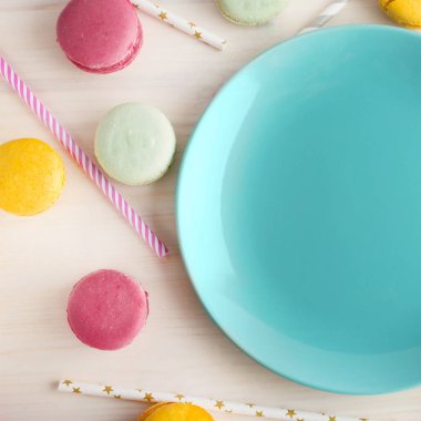 Boş mavi parlak plaka, çevresinde macaroons ve tüpler bir kokteyl için lezzetli bir tatlı. Metin için yer. Festival düzen, şablonu. Kopya alanı