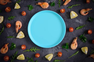 Boş bir mavi levha karanlık dokulu arka plan ortasında yatıyor. Çevresinde limon, maydanoz, domates ve karides dağılmış. Fotoğraf vignette, alay etmek yukarıya ile.