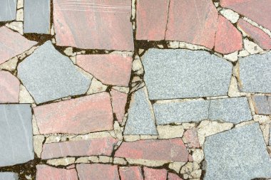Arka plan bir mozaik doku ile. Büyük gri ve soluk kırmızı granit parçaları düzensizce sıralanır. Güzel Foto.
