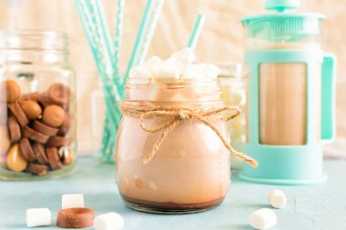 Ön planda bir kavanoza sıcak bir içecek. Kakao ile hatmi üstte. Arka plan bulanık. Güzel bokeh. Romantik parlak sabah.