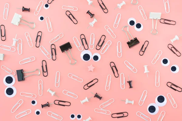 Kukla gözleri ve pembe bir arka plan üzerinde klipler arasından bir olağandışı, komik yüz. İleti örneğini düzensizce dağınık olduğunu. Alışılmadık bir arka plan klipleri ve büro düğmeleri. Güzel resim üst.